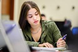 Photo of student taking notes in class