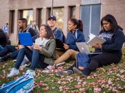 Group of students sitting outside 和 smiling