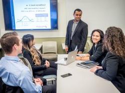 Students gathered at table watching presentation