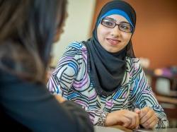 Student with hijab and glasses smiling