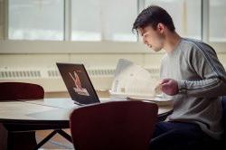 Student working at a computer seated at a desk