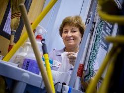 Housekeeper looking over housekeeping cart of products