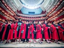 Master's Degree graduates in red caps and gowns