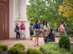 Students in professional dress smiling outside on campus