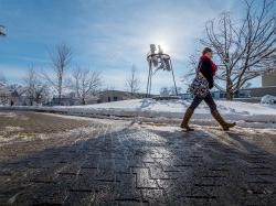 Photo of a student walking across the snowy campus of Montclair State University