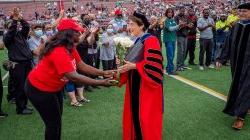 Dr. Cole shaking hands with a parent attending commencement