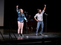 Nelly Bess and SNC on stage with arms raised.