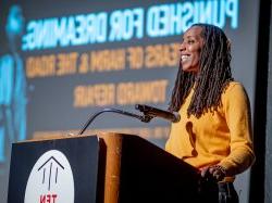 Bettina L. Love smiles as she speaks at a podium.