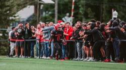 A Montclair football player, #0, is hyped up by a crowd of fans.