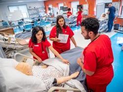 Nursing students preparing manikin for examination.