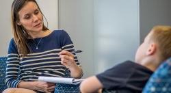 Image of a clinician talking with a child in a therapy session.