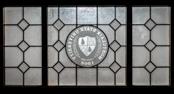 Image of a decorative glass panel with the Montclair State shield incorporated.