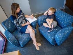 photo of child and adult sitting in chairs