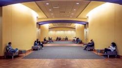 Photo inside University Hall of a few people sitting in the hallway.