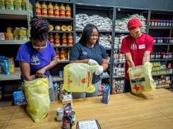 Three students bagging food