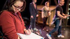 Students and Faculty discussing theatre set